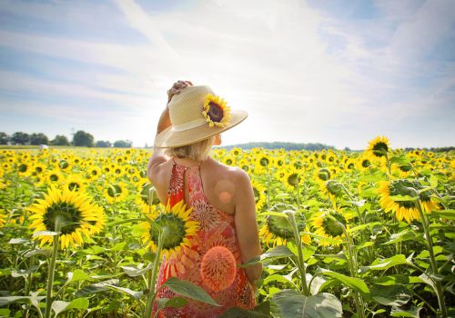 vrouw in een zonnig bloemenveld met zonnebloemen